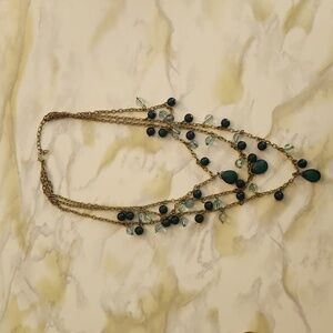 Multilayered beaded necklace. One size fits all. Beads are shades of blue/green.